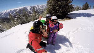 Family enjoying skiing in snowy mountains.