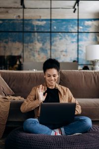 Woman video calling using laptop at home.