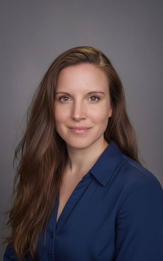 Smiling person in blue shirt headshot.