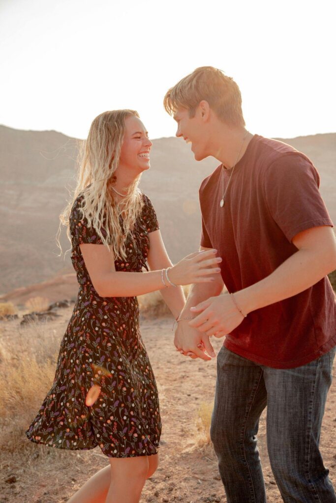 Couple laughing in a sunlit landscape