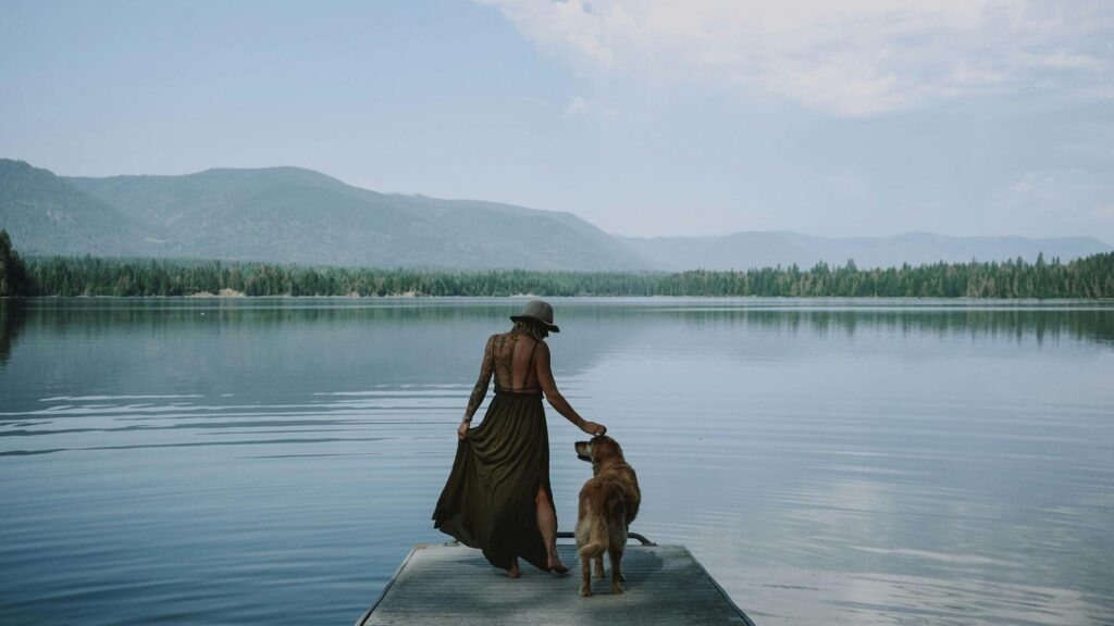 Woman and dog on dock by lake