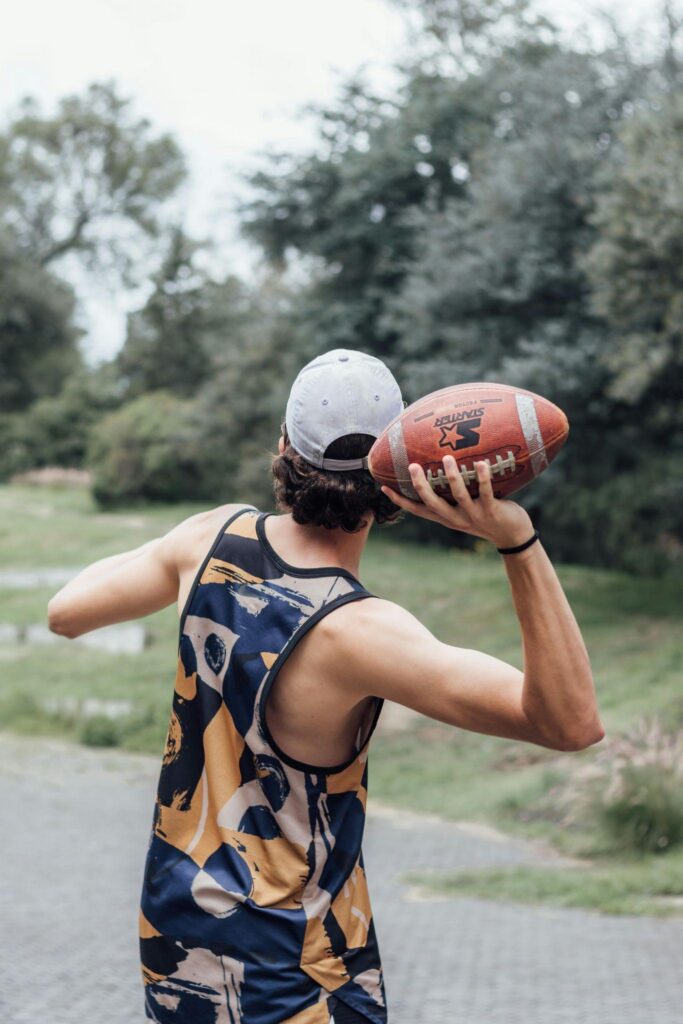 Person preparing to throw a football outdoors.