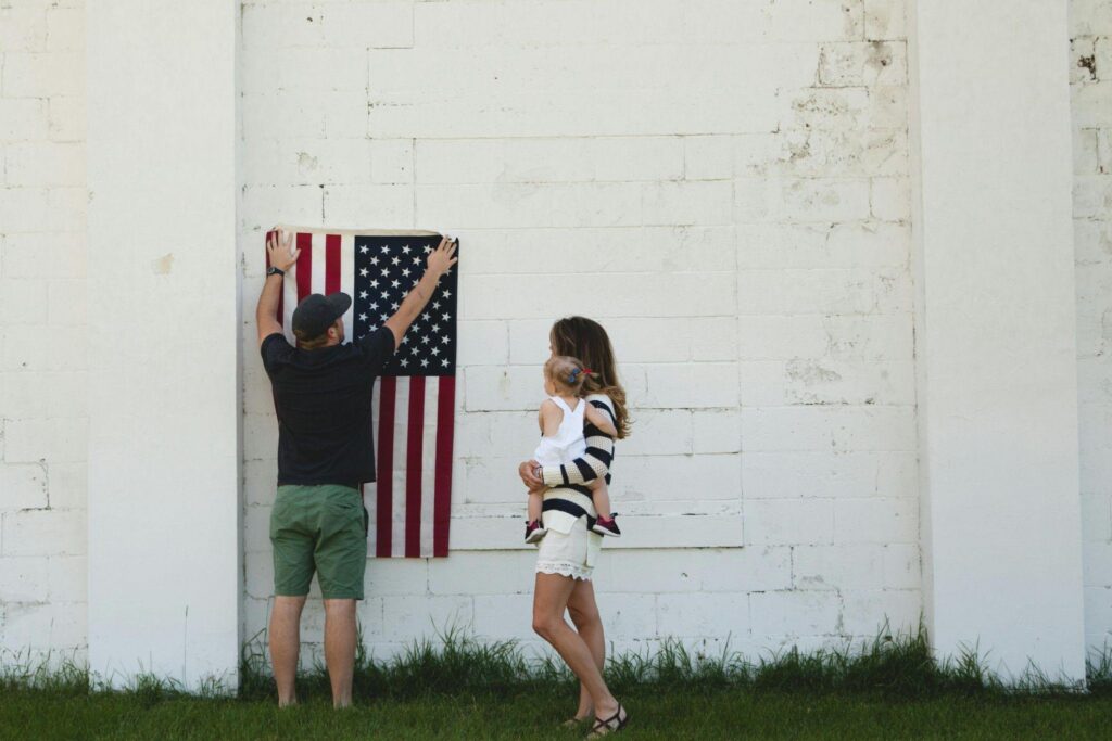 Family hanging American flag on wall