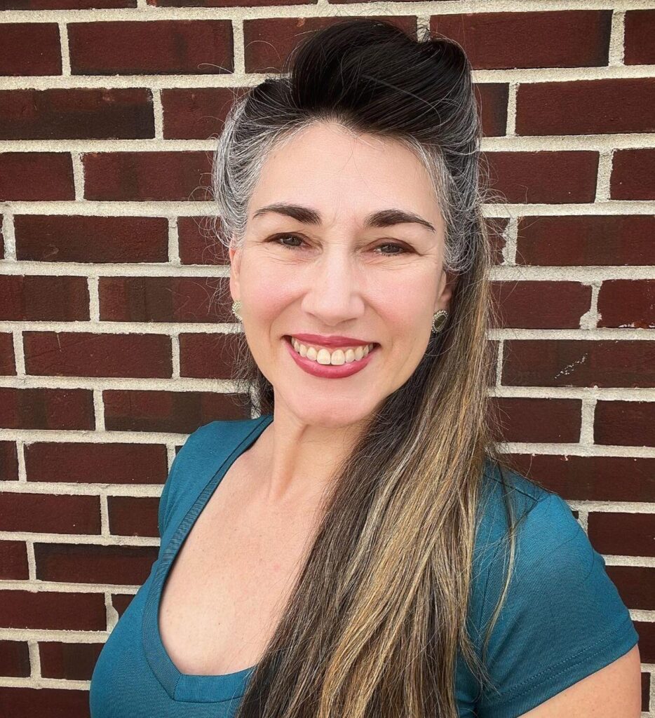 Woman smiling against brick wall