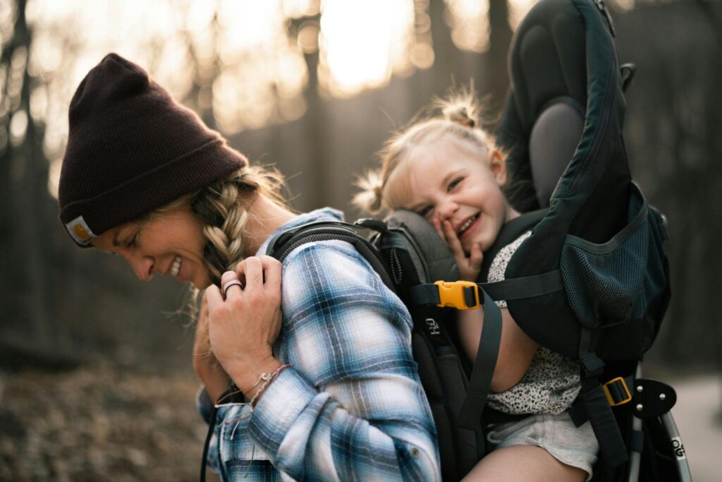 Woman carrying child in backpack carrier