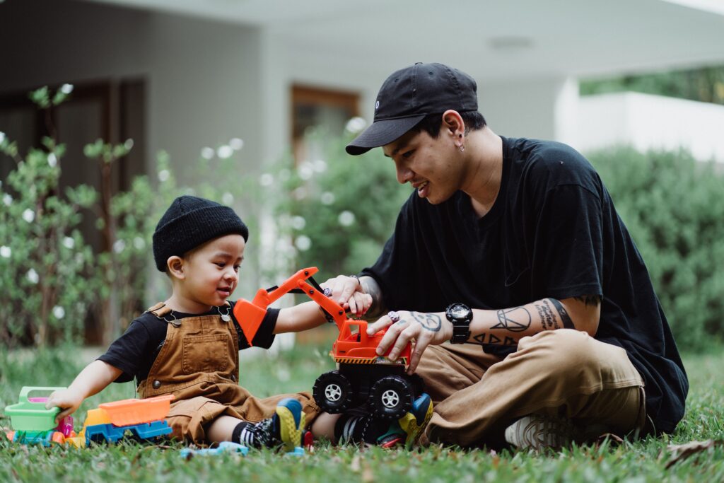 Father and son playing with toy truck