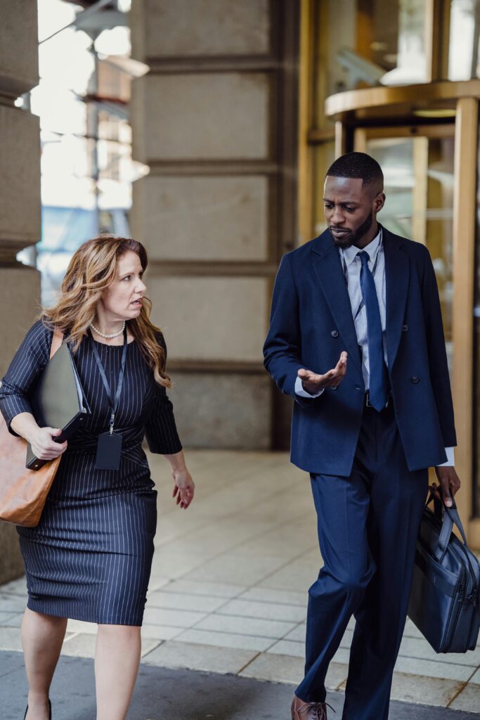 Two professionals walking and talking outside building