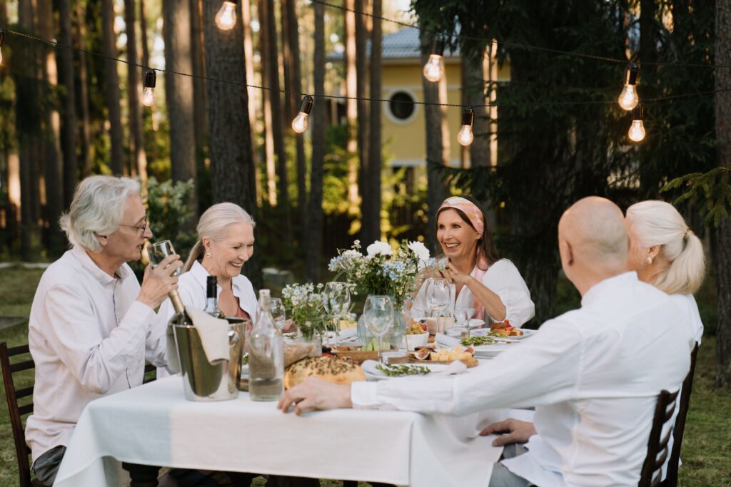 Group dining outdoors with string lights.